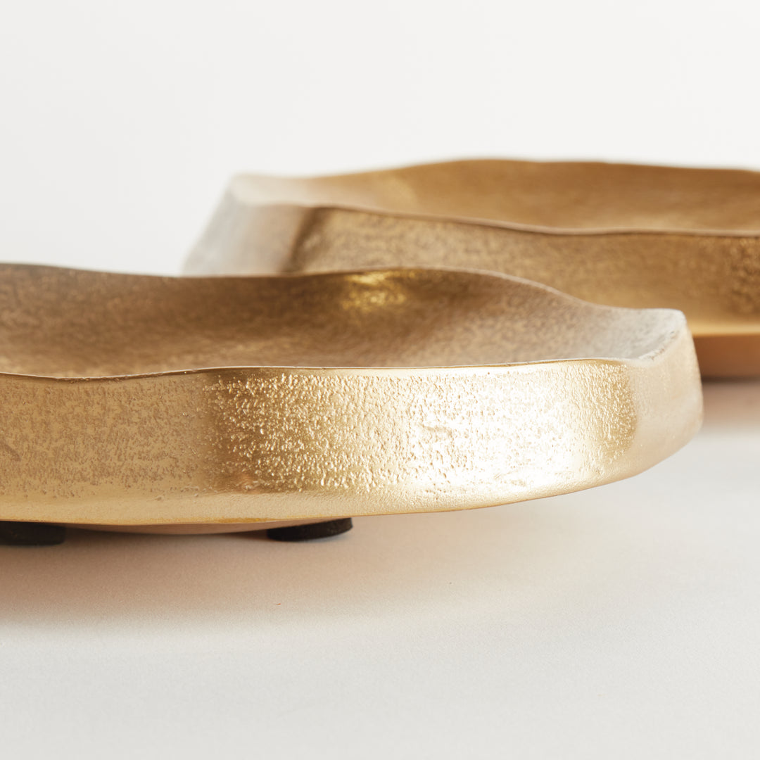 Side detail of gold decorative bowls showing thick aluminum edges, subtle texture and low profiles on white - Modern Organic
