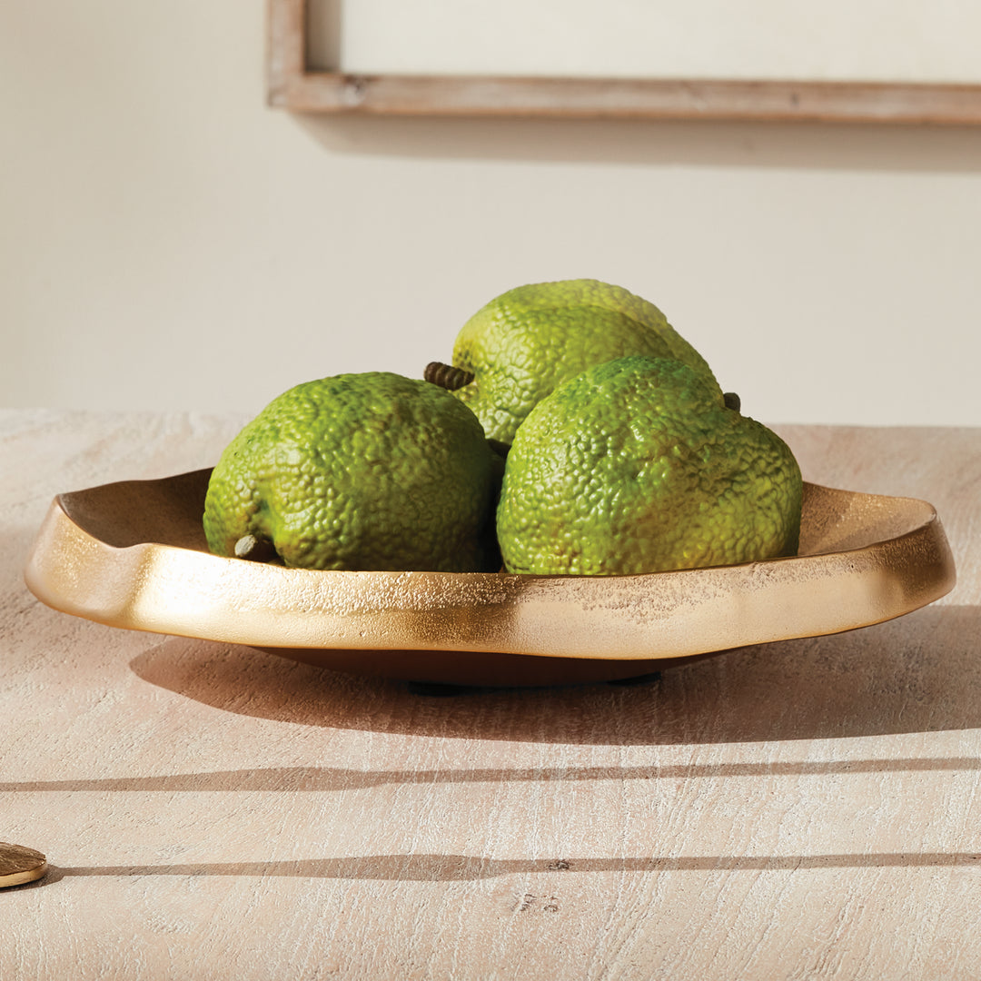 Gold decorative aluminum bowl with green decorative objects, a thick organic rim and textured finish on wood - Modern Organic