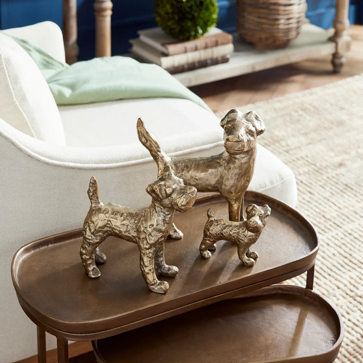 Gold dog figurines set styled on tabletop tray near chair, cast aluminum sculptures adding warmth and character – Transitional