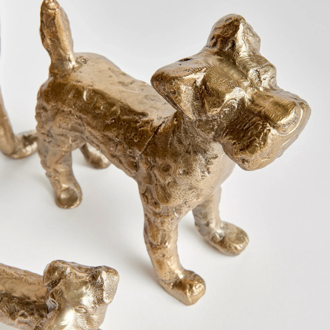 Gold cast aluminum dog figurines with detailed texture and expressive form, close view of decorative animal sculptures – Transitional
