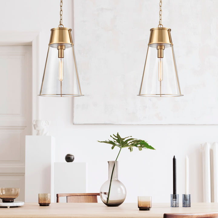 Pair of gold glass cone pendant lights above a console styled with a vase, greenery and candleholders, Transitional style