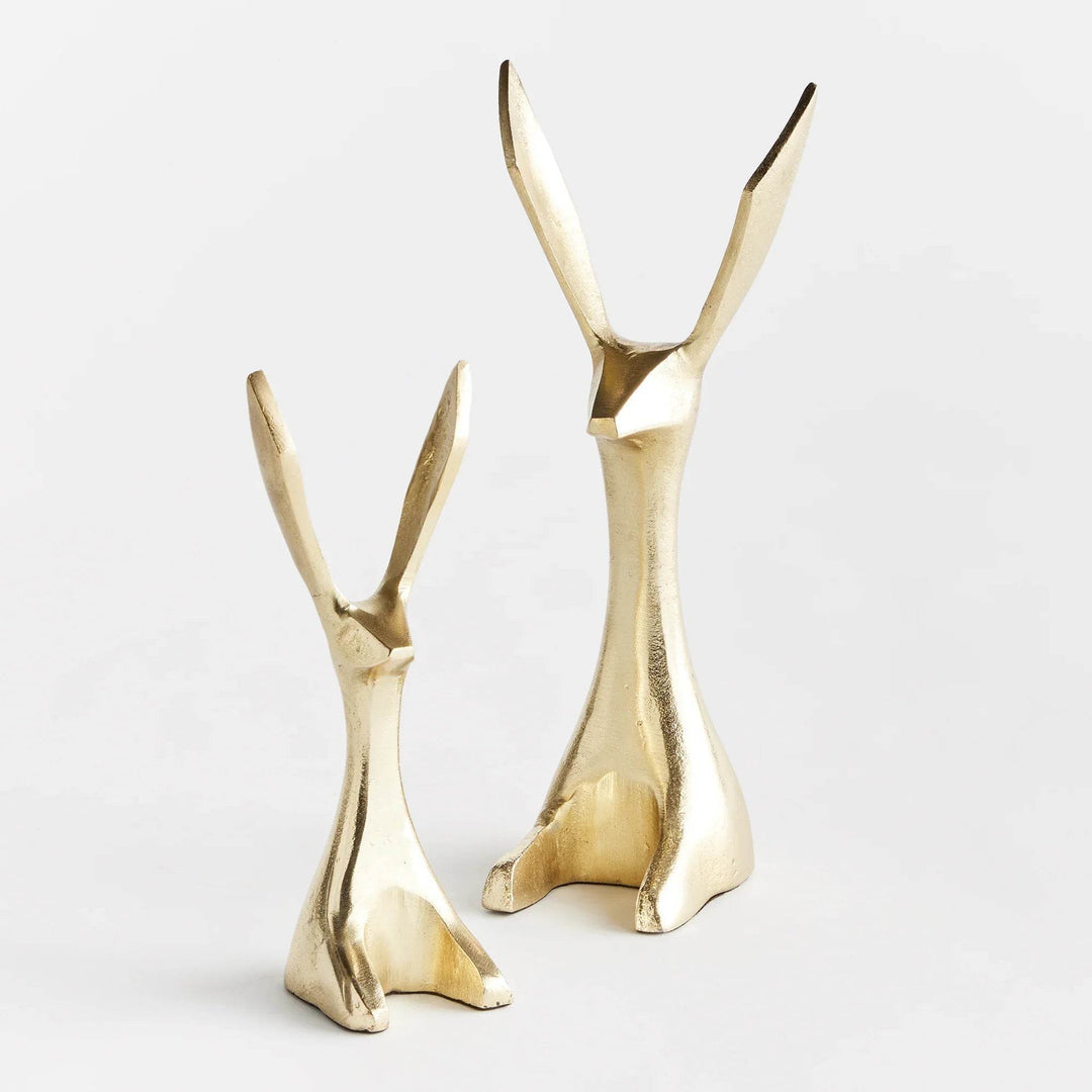 Front view of abstract gold bunny statues with elongated ears, posed in profile – Modern Coastal.