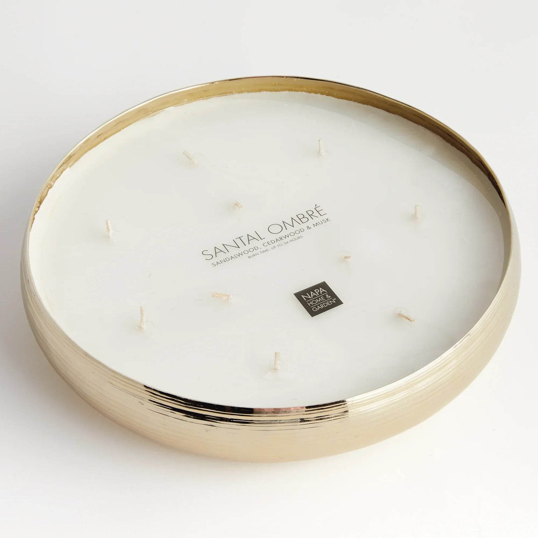 Gold metal multi-wick candle showing fragrance label for sandalwood, musk, and cedarwood blend in round vessel – Modern Organic.

