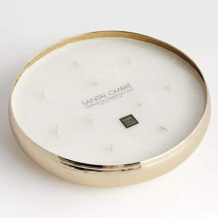 Gold metal multi-wick candle showing fragrance label for sandalwood, musk, and cedarwood blend in round vessel – Modern Organic.

