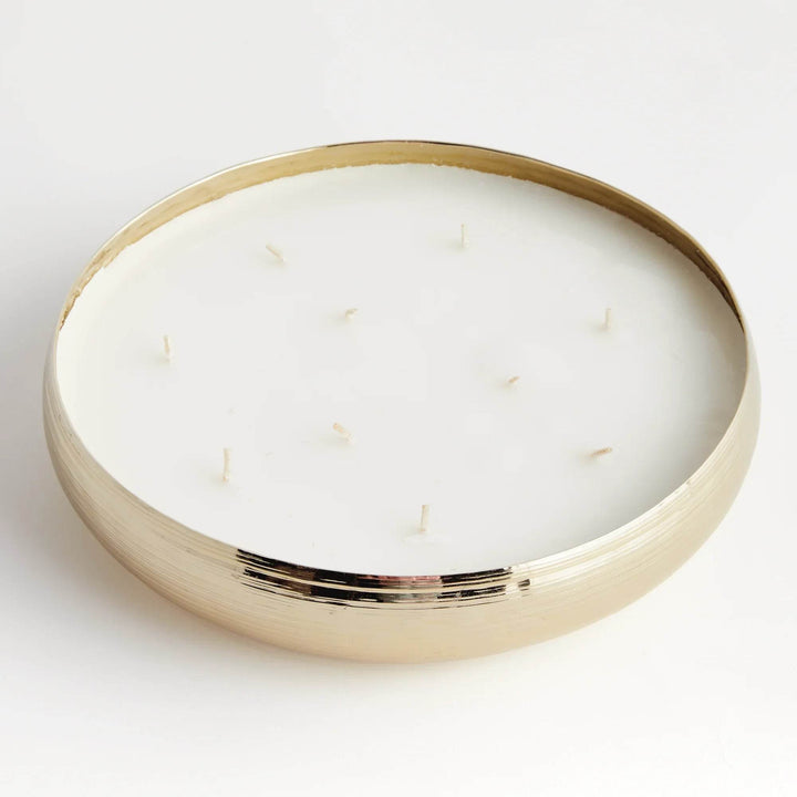 Gold metal multi-wick candle unlit with soy wax blend in shallow round bowl-shaped vessel – Modern Organic.

