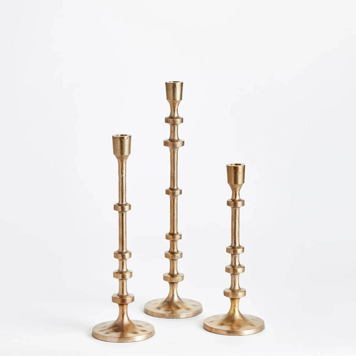 Gold taper candle holder stem showing sculptural notched rings and metallic finish – Modern.