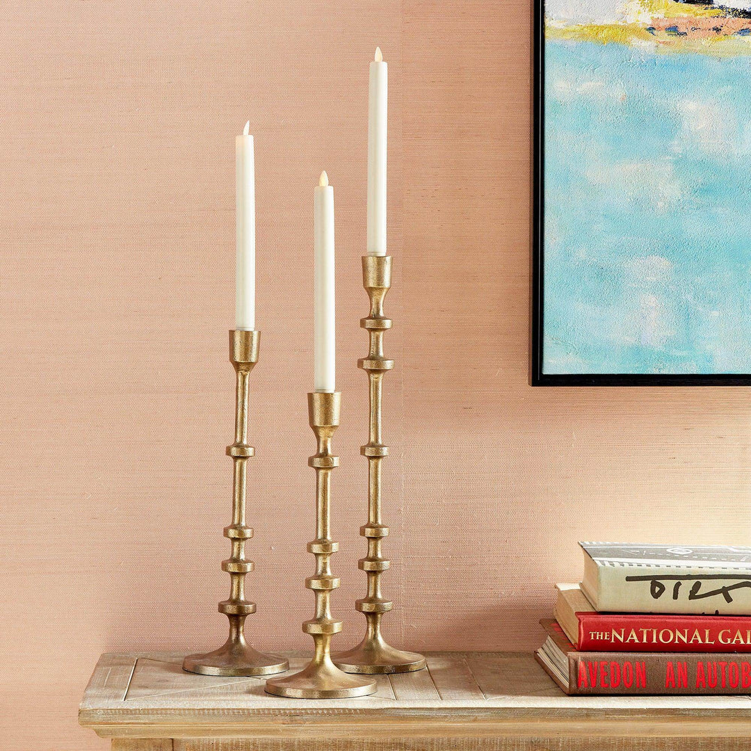 Trio of gold taper candle holders displayed on a console table with books, slim tall design for modern interiors – Modern.