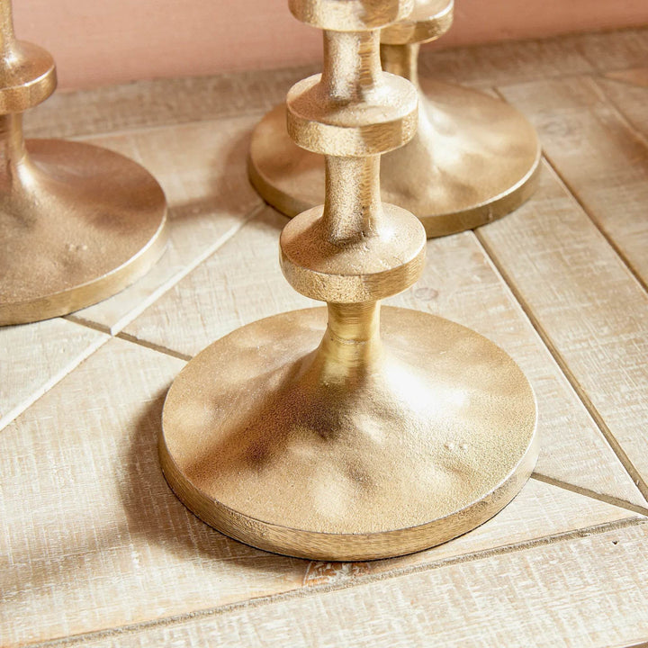 Set of three tall gold taper candle holders with abacus-inspired stems on white background – Modern.