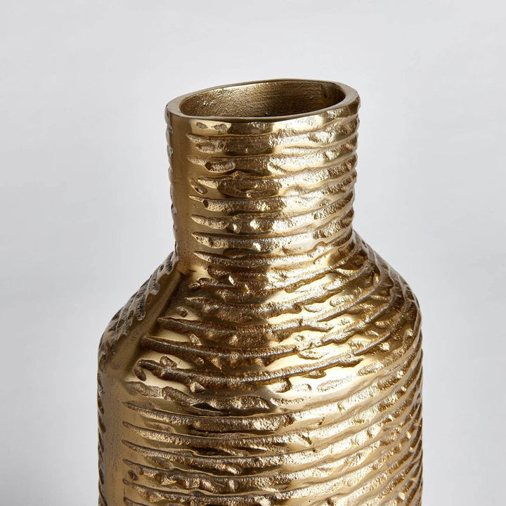 Closeup of rim on small gold aluminum vase, highlighting warm metallic finish and texture
