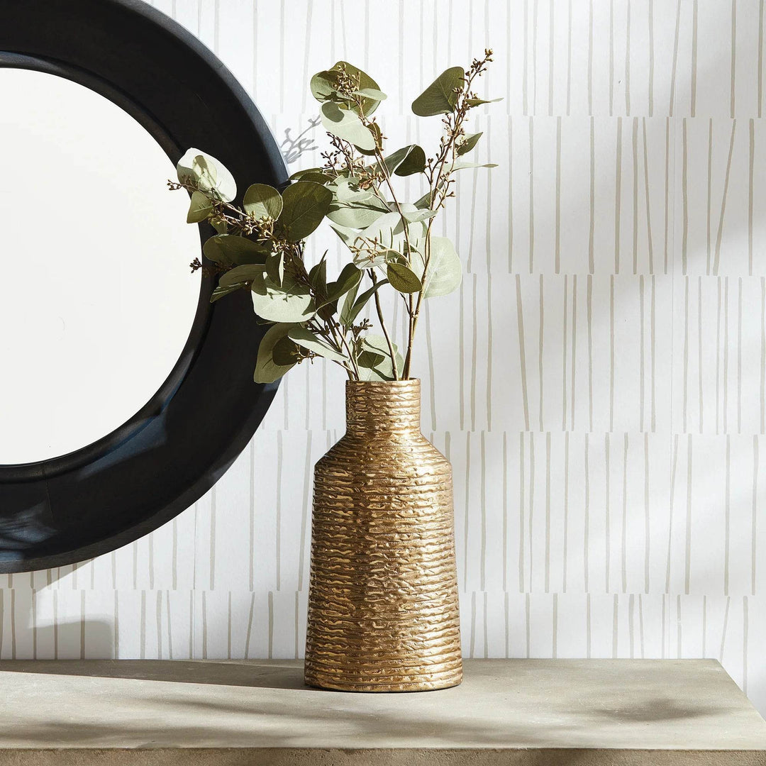 Small gold textured aluminum vase styled with faux greenery on console, modern classic decor

