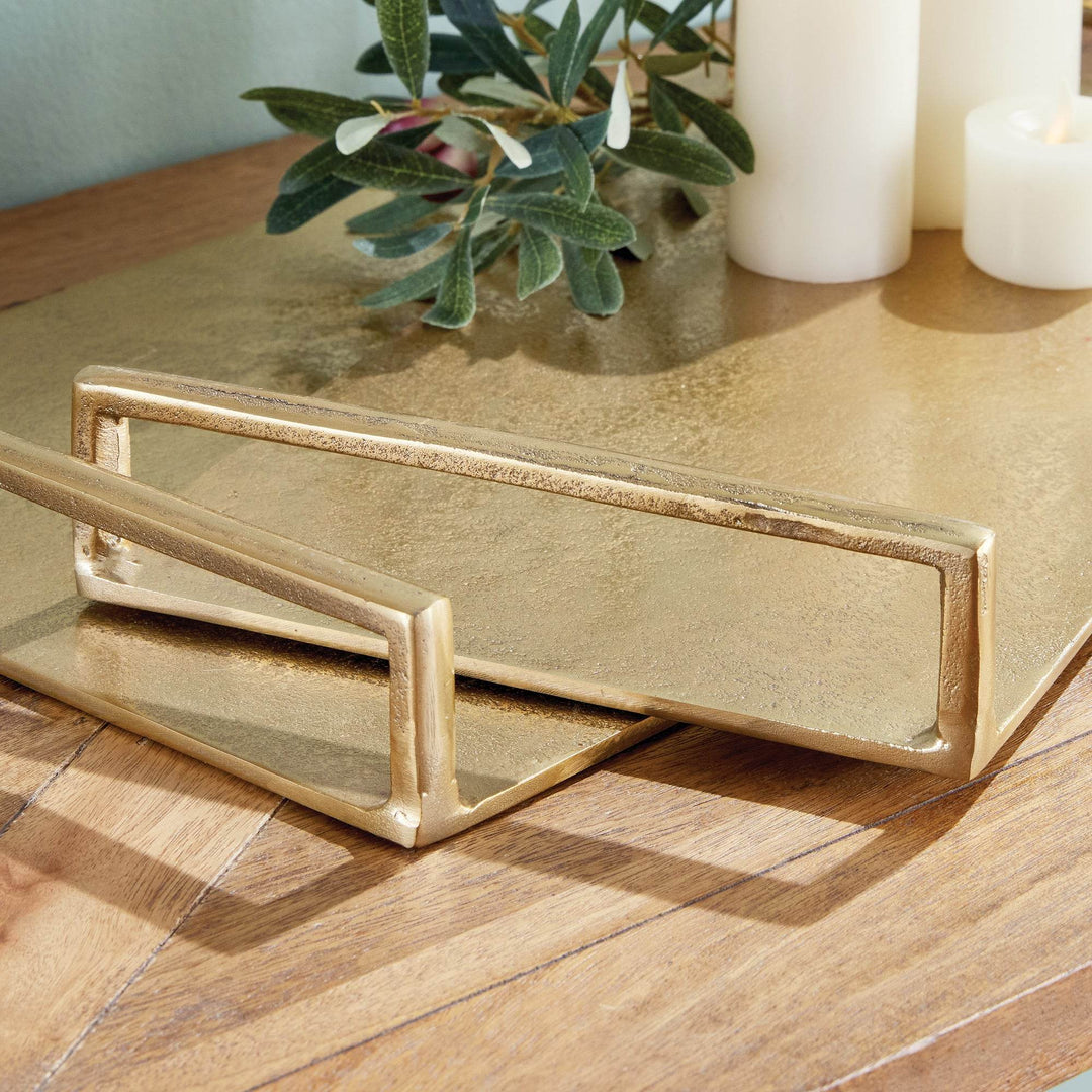 Close-up of rectangular handle on gold textured decorative tray, cast aluminum build with tactile surface – Transitional.