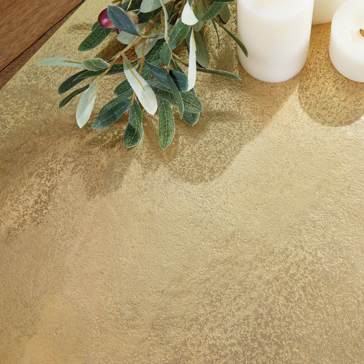 Gold textured decorative tray on wood with greenery and candles, highlighting tactile surface and warm finish – Transitional.