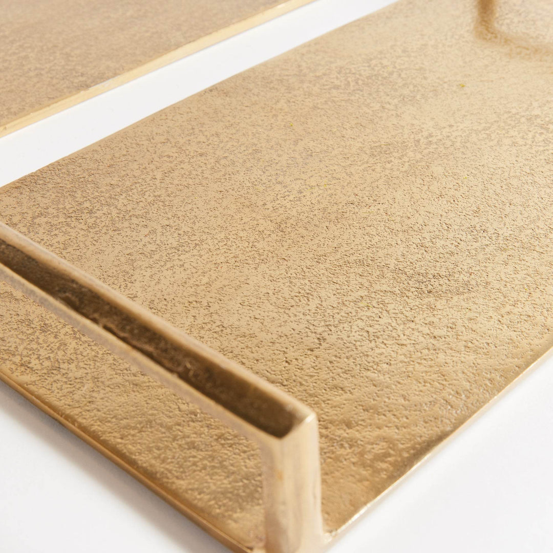 Macro close-up of textured gold aluminum surface on decorative tray, subtle hammered finish with soft sheen – Transitional.