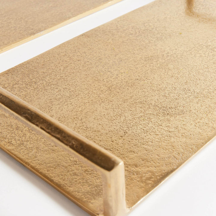 Macro close-up of textured gold aluminum surface on decorative tray, subtle hammered finish with soft sheen – Transitional.