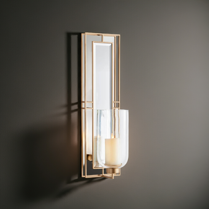 Gold wall sconce with glass hurricane and mirrored back panel, 28 inch tall, shown lit with LED candle for warm ambient glow – Transitional décor.