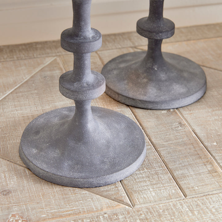 Close-up of gray aluminum candle holder base with textured sculptural finish and stacked silhouette – Transitional