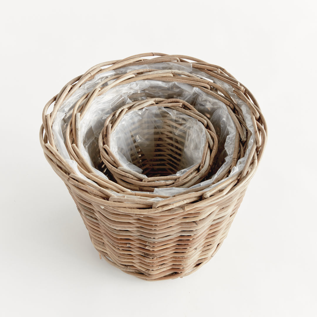 Three tapered rattan basket planters nested together, showing the graduated sizes and fitted clear liners, Modern Farmhouse