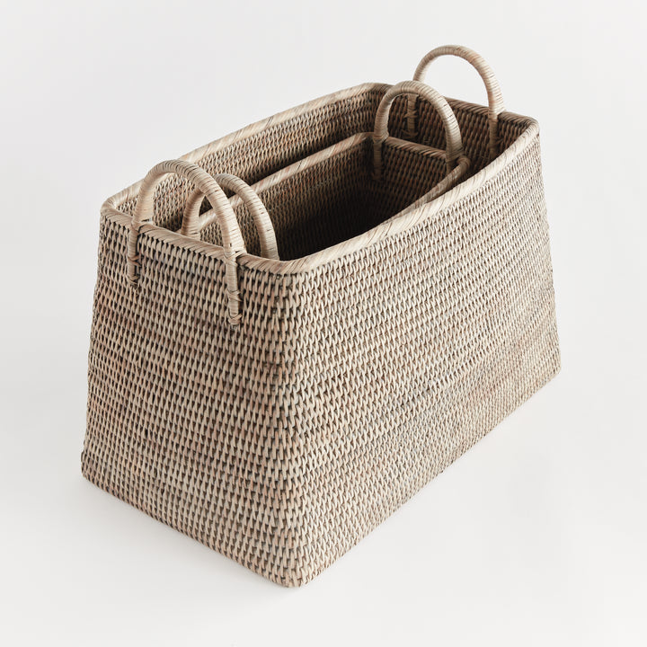 Two graywash rattan magazine baskets nested together, showing the graduated sizes, interiors and loop handles, Transitional