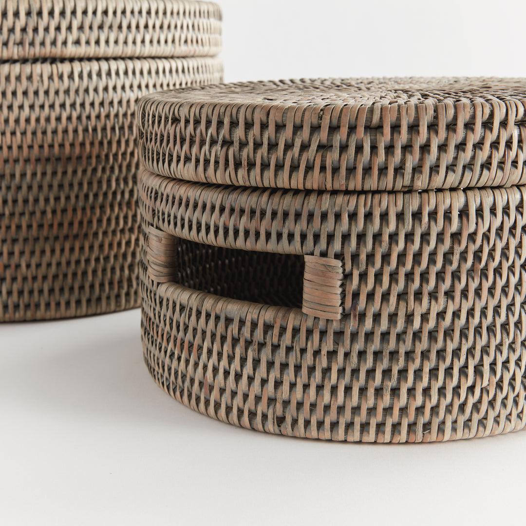 Close view of graywash rattan boxes showing the fitted lid edge, tight weave and rectangular cutout handle, Transitional