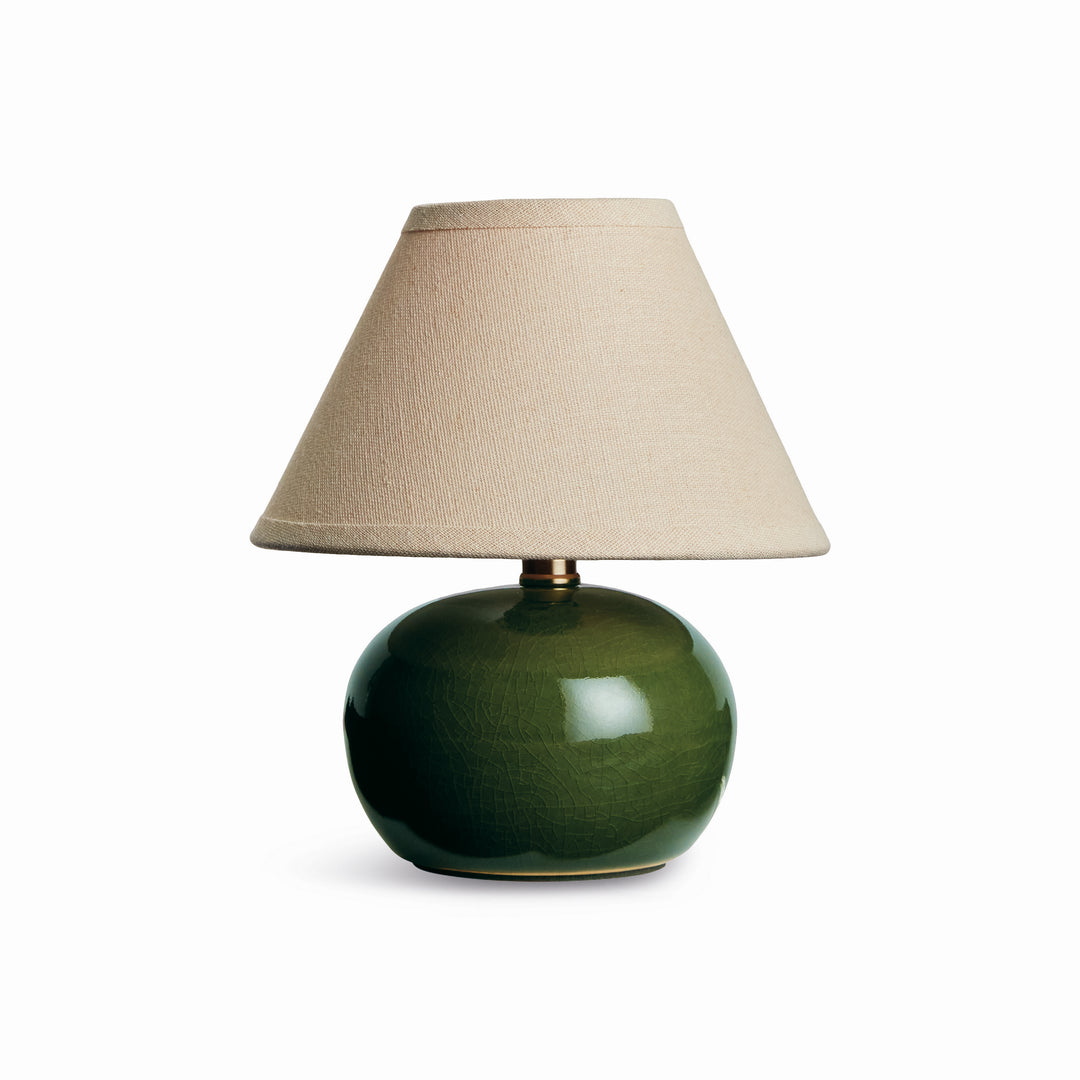 Green ceramic mini table lamp with a rounded glazed base and tapered cream linen shade on plain white - Coastal Transitional