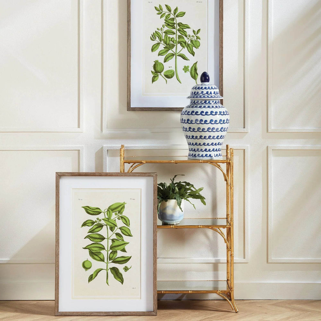 Set of guava botanical prints leaning on wall with stacked styling and wood frames