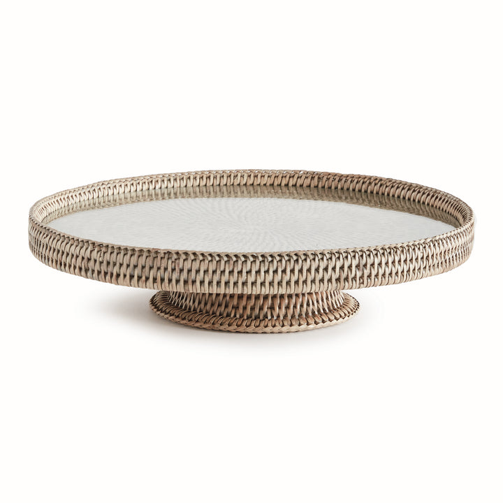 Hadley graywash pedestal stand with a round glass insert, woven rim and low circular base against a white background. Coastal