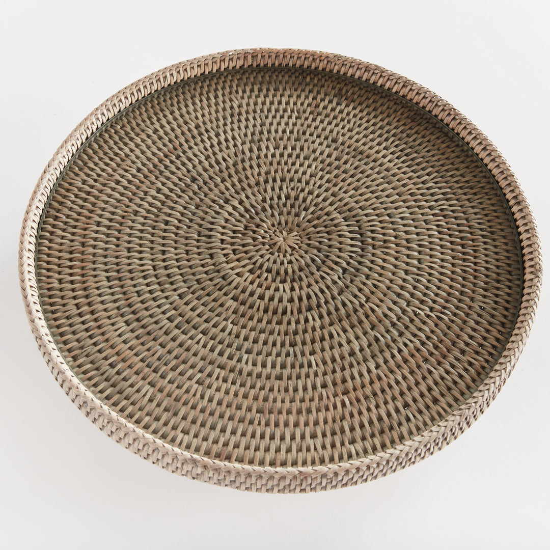 Top view of Hadley graywash rattan pedestal stand with radiating texture beneath the round glass insert and rim. Coastal