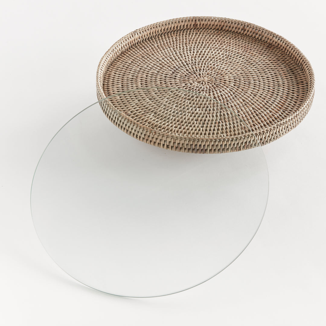Hadley graywash rattan stand with its removable round glass insert placed separately beside the raised platform. Coastal