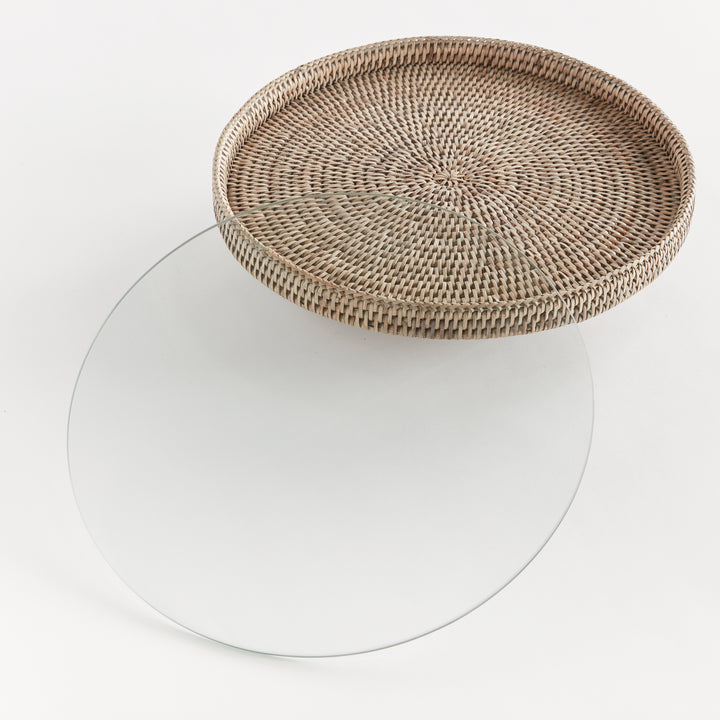 Hadley graywash rattan stand with its removable round glass insert placed separately beside the raised platform. Coastal