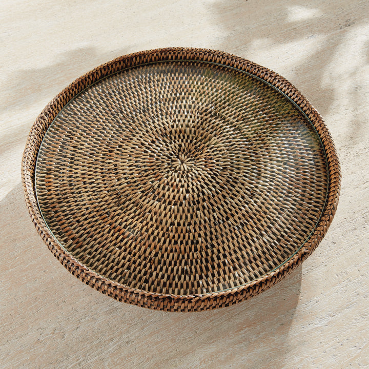 Overhead view of Hadley warm brown pedestal stand showing the radiating rattan weave beneath its round glass insert. Coastal
