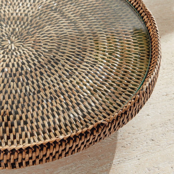 Close view of Hadley warm brown stand showing the glass edges over woven rattan within the wrapped circular rim. Coastal