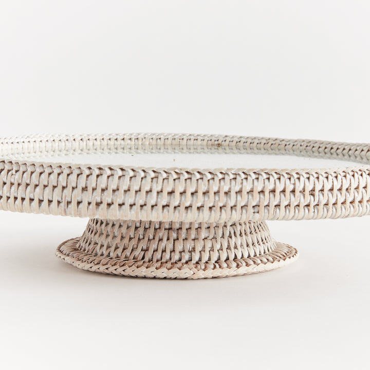 Close view of Hadley whitewash rattan pedestal stand showing its wrapped rim, glass insert and small woven base. Coastal