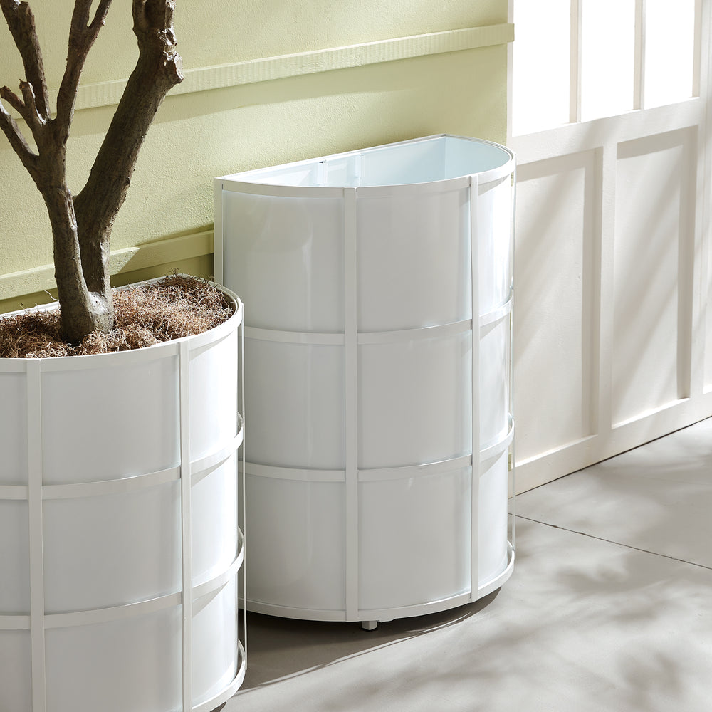 Pair of white half-round planters styled near entryway windows, blending modern and heritage cues in a transitional garden setting.