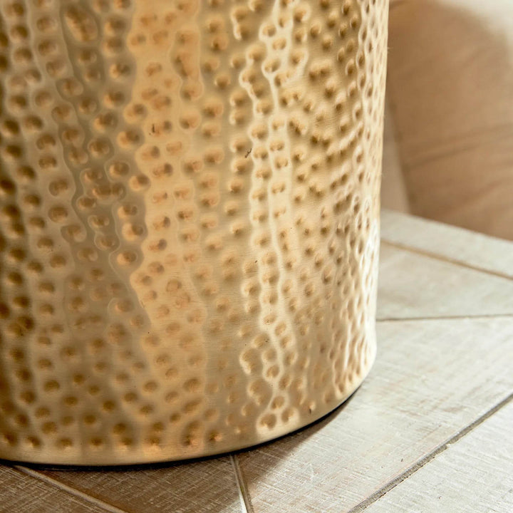 Close-up of hammered brass base with sculptural texture in organic luxe style


