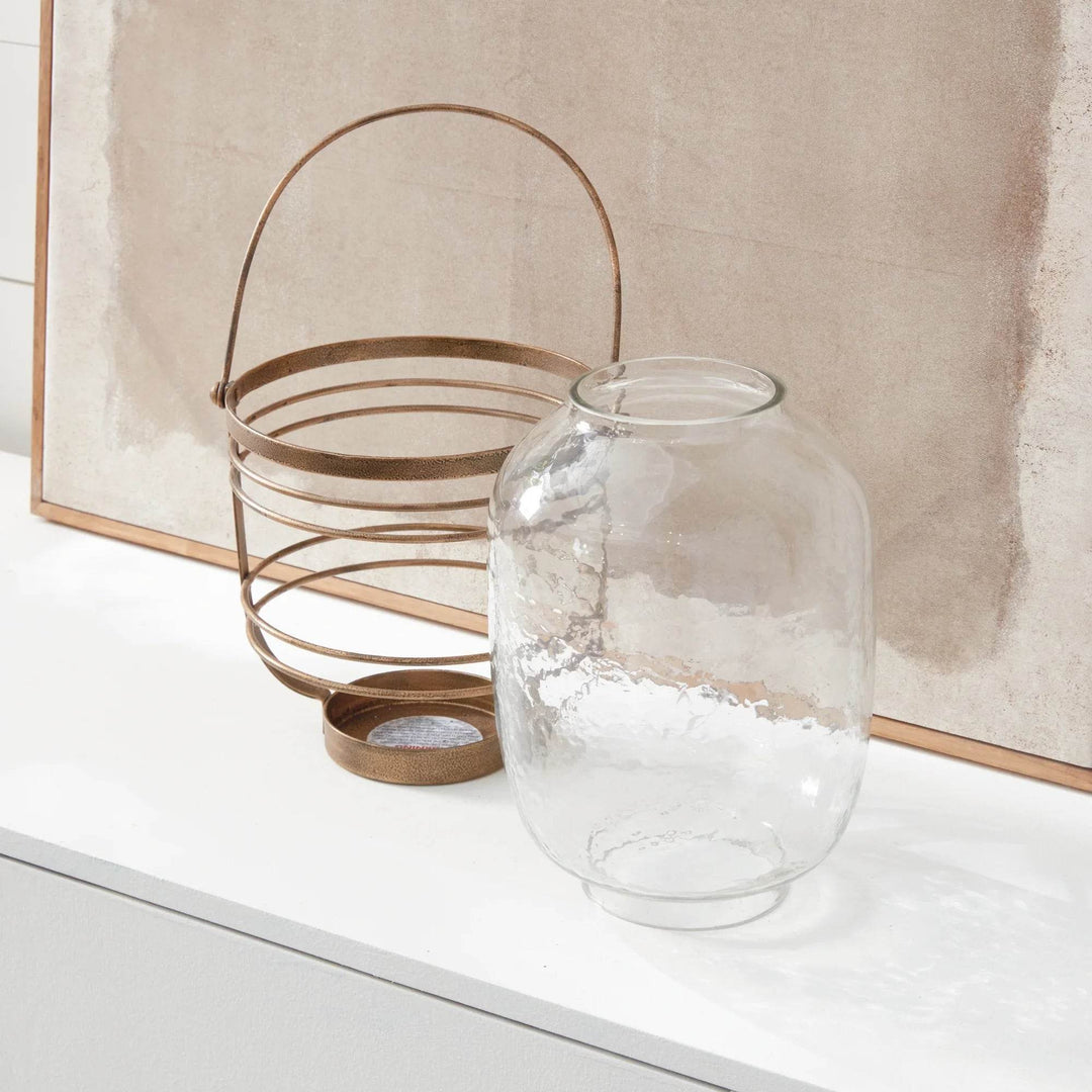 Hammered glass hurricane with antique gold iron frame shown with vessel separated from cage for cleaning access – Coastal