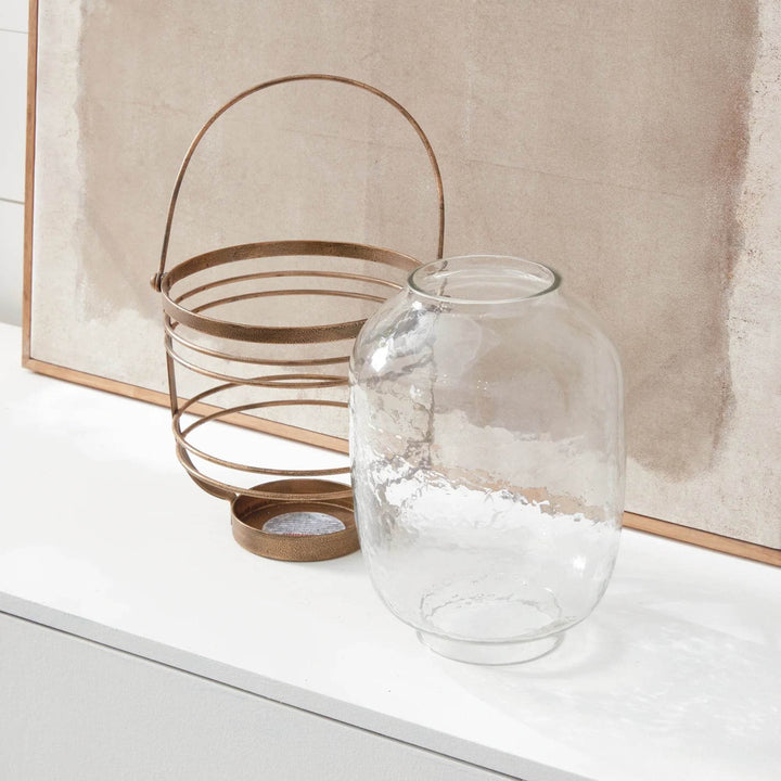 Hammered glass hurricane with antique gold iron frame shown with vessel separated from cage for cleaning access – Coastal