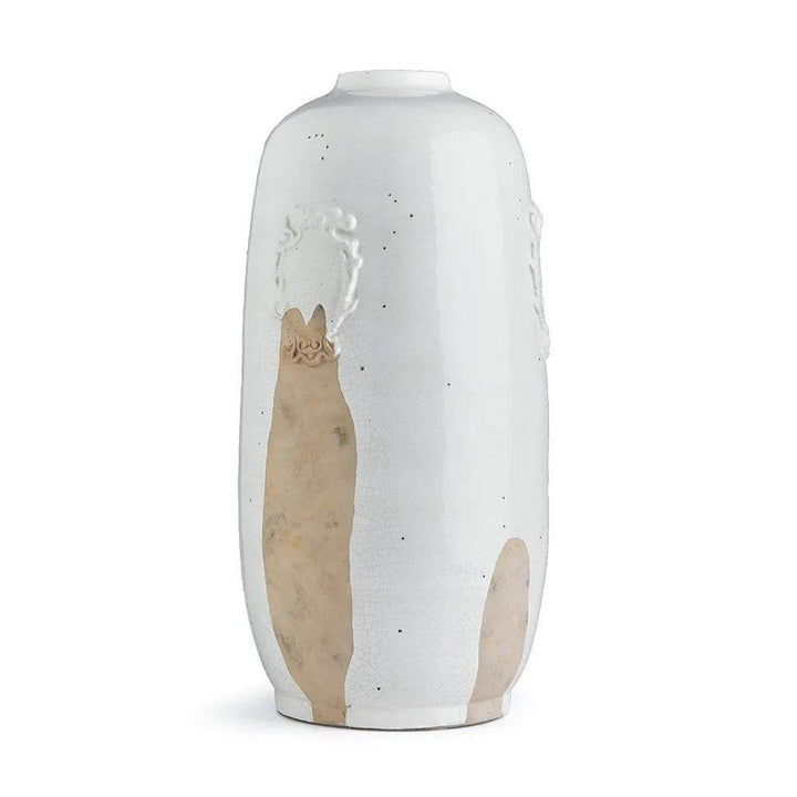 Tall white ceramic vase with clay detail displayed in natural light on a table, showcasing artisan glaze and texture.

