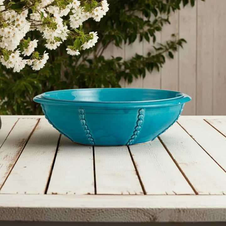 Aqua blue handmade bowl with textured detail styled on whitewashed surface