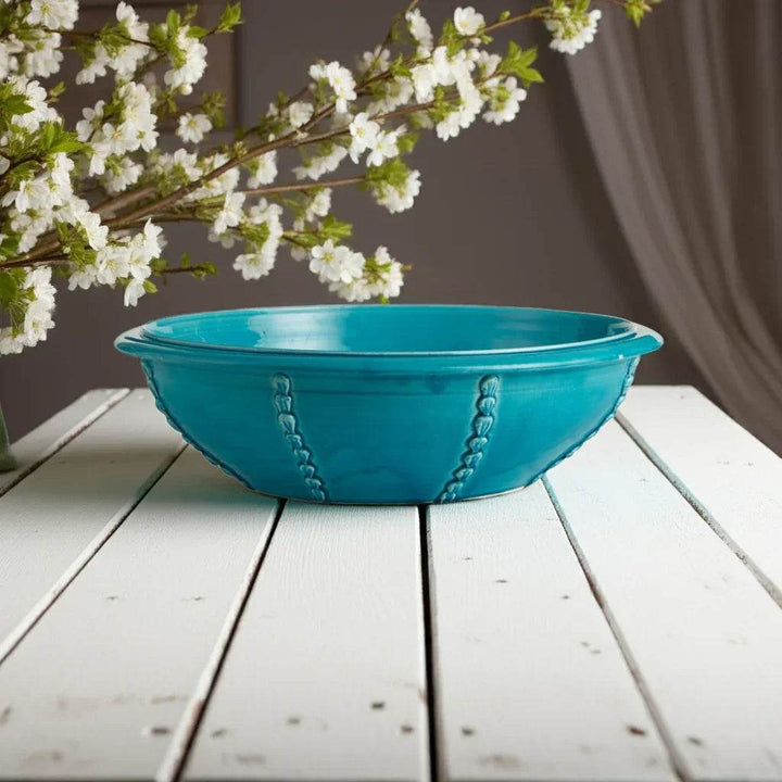 Side angle of large handmade Italian ceramic bowl in deep aqua tone