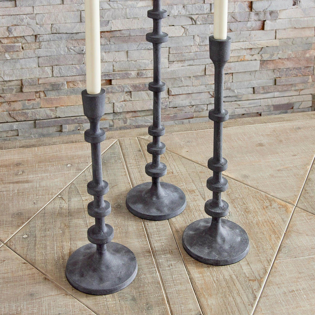 Two industrial black taper candle holders photographed together, highlighting bases and column detail – Contemporary