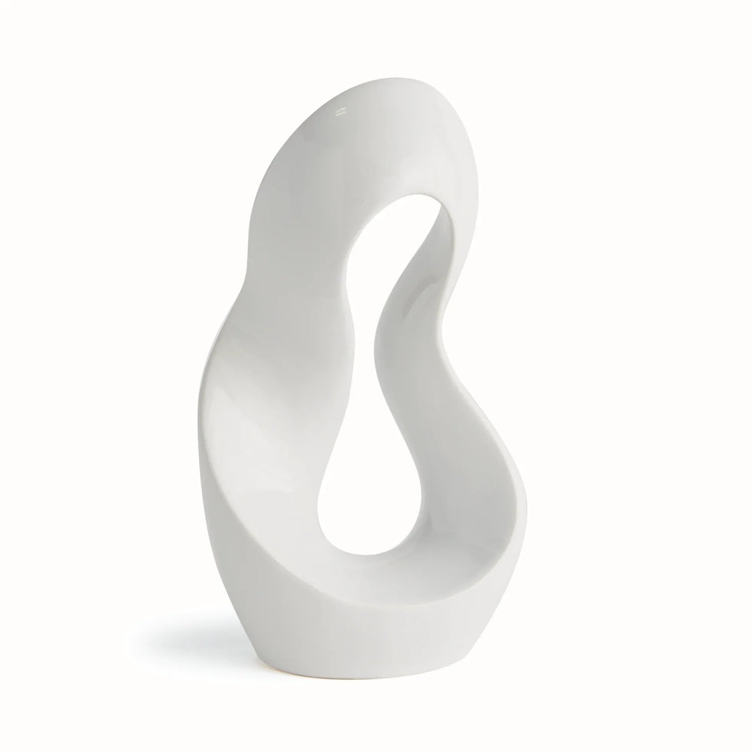 Three-quarter side view of abstract clay sculpture in alabaster gloss finish, showing organic arc shape and sculptural negative space.