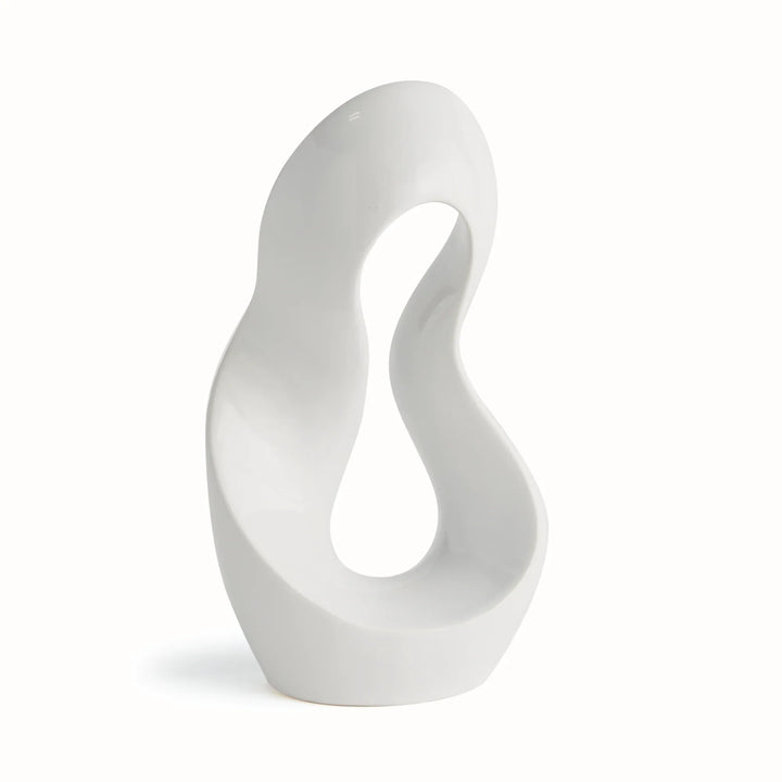 Three-quarter side view of abstract clay sculpture in alabaster gloss finish, showing organic arc shape and sculptural negative space.