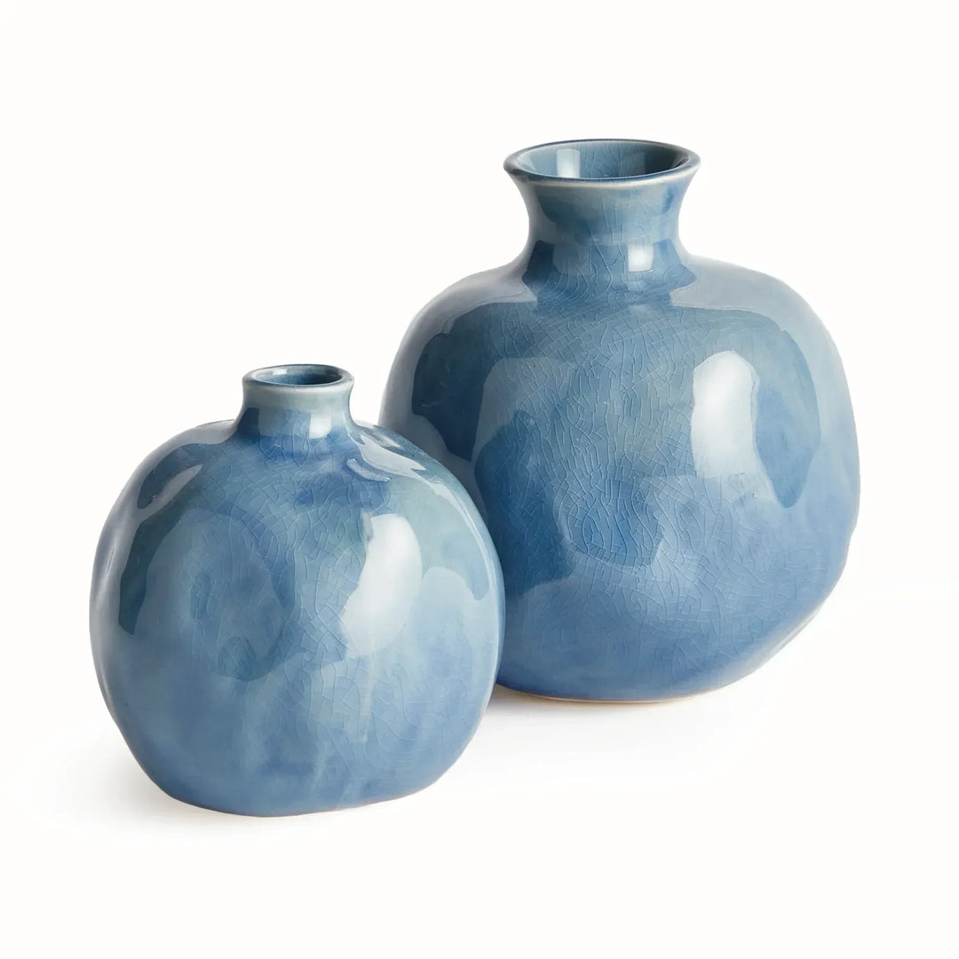 Blue ceramic bud vases in a graduated pair, with rounded bodies, short narrow necks and a richly glazed surface. Transitional