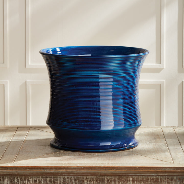Blue Italian ceramic cachepot vase styled on a wooden tabletop
