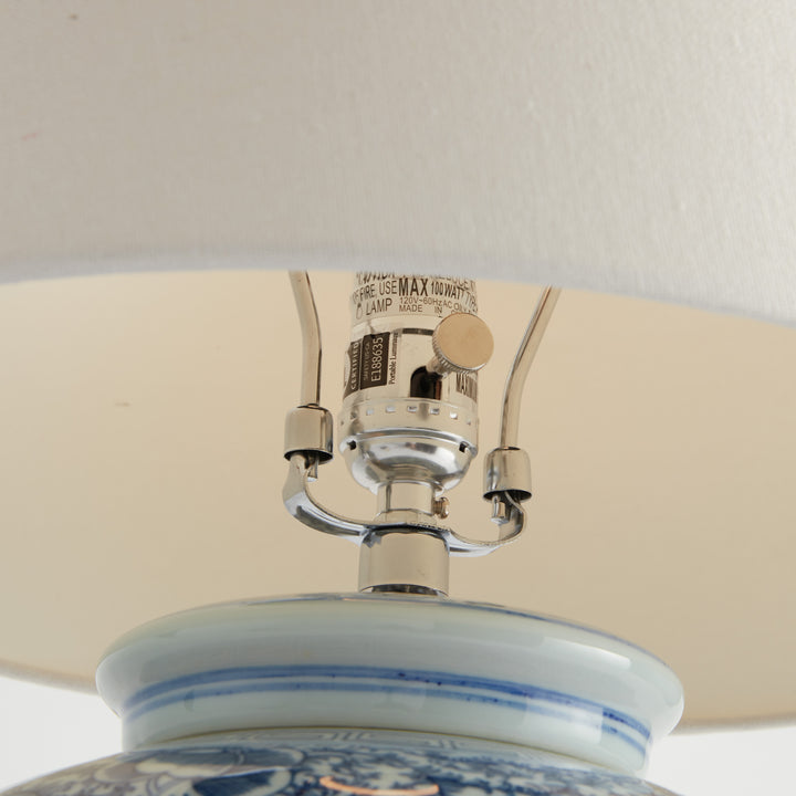 Close-up of nickel-finish socket and harp hardware on porcelain table lamp with visible 100W E26 label – Transitional style.