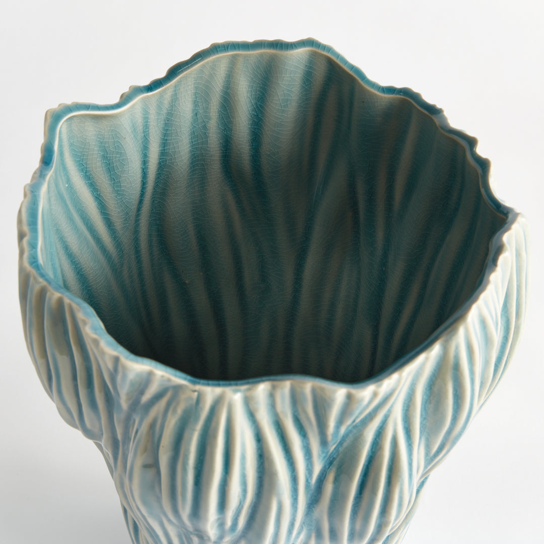Angled view into a large blue ceramic vase showing flared uneven rim and flowing texture against white, Coastal Transitional