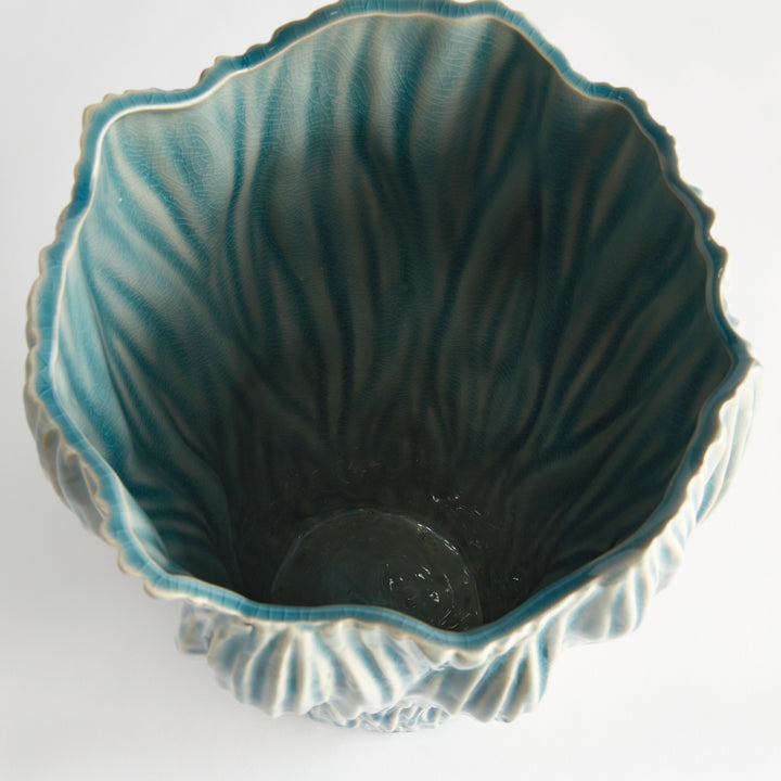 Overhead view into a large blue reactive glaze ceramic vase with an uneven rim and a colored interior, Coastal Transitional