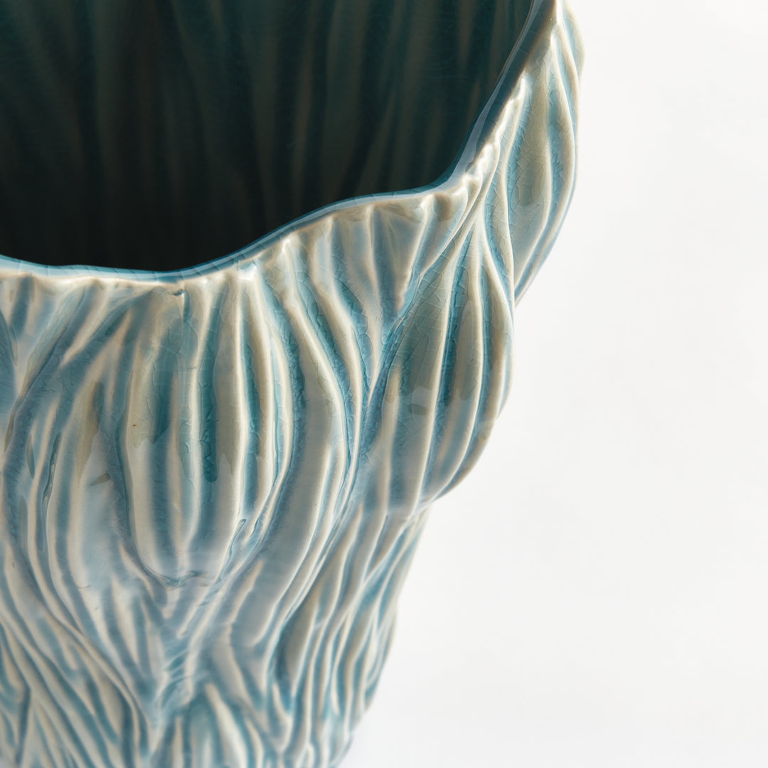 Close view of a blue ceramic vase showing the reactive glaze, flowing ridges and irregular upper edge, Coastal Transitional