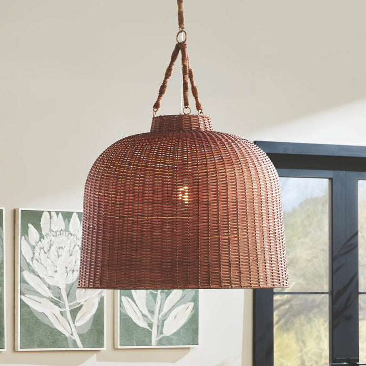 Large brown woven rattan pendant hanging in a light room, with framed botanical artwork and dark window nearby, Coastal style