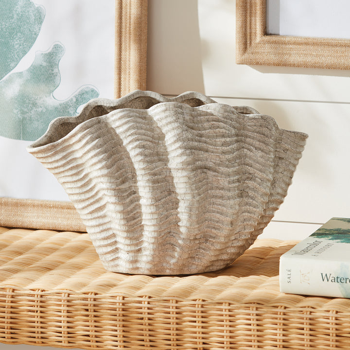 Large cream shell vase styled on woven console beside framed artwork and books, showing its flared form, Coastal Transitional